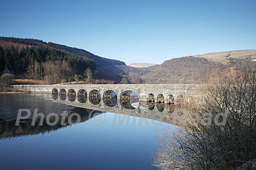 Caban-coch Reservoir and bridge to the Claerwen Valley reflected in the water, Powys, Wales, United Kingdom